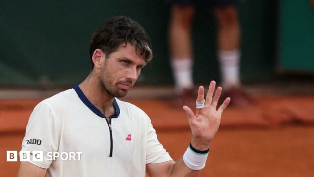 Cameron Norrie raises his hand