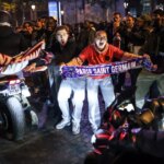 La voiture tondait les fans de football et les flics utilisent des gaz lacrymogènes après la perte de Ligue des champions d'Arsenal