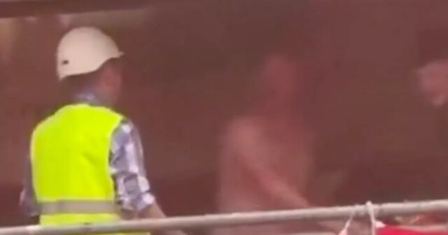 Man Utd Fan danse nue sur l'échafaudage à Bilbao alors que le travailleur exige qu'il descend
