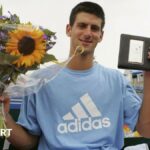 Novak Djokovic holds aloft his prizes for winning the Dutch Open in July 2006