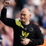 Alex Neil raises his fist to salute the Millwall fans