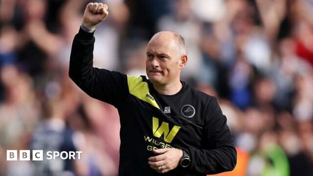 Alex Neil raises his fist to salute the Millwall fans