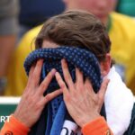 Alex de Minaur covers his face with a towel at the French Open