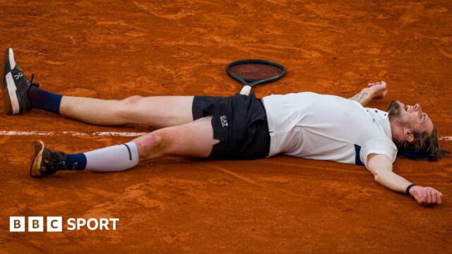 Alexander Bublik lays on the ground after defeating Jack Draper at the French Open
