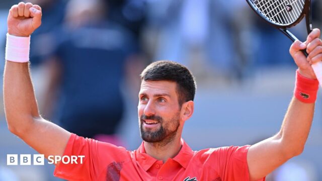Novak Djokovic raises his arms in celebration after victory over Cameron Norrie at the French Open