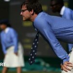 Wimbledon line judge leans forward to watch the line