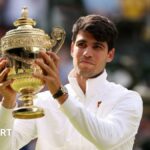 Carlos Alcaraz holds the Wimbledon men's singles trophy