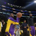 Los Angeles Lakers strážca Bronny James vľavo a postúpil LeBrona Jamesa pred basketbalovou hrou NBA proti Minnesote Timberwolves 22. októbra 2024 v Los Angeles.