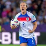 Lucy Bronze clenches her left fist and makes an emotional facial expression during England's Euro 2025 quarter-final