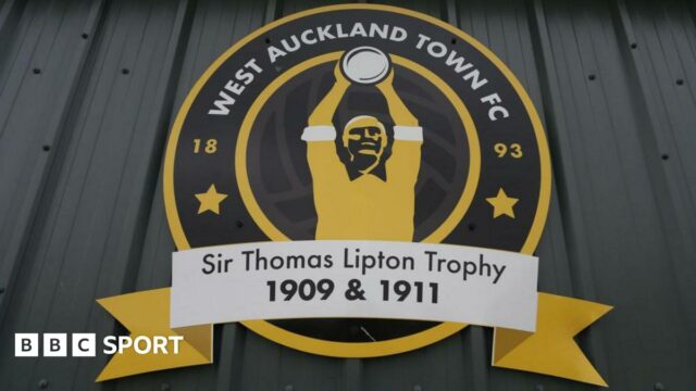 An image of West Auckland Town's crest which features the Sir Thomas Lipton Trophy 1909 & 1911.