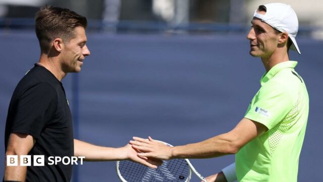 Neal Skupski and Joe Salisbury high-five after a point