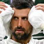 Novak Djokovic holds an ice towel on his head at a change of ends