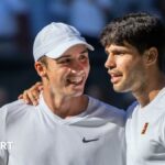 Oliver Tarvet is embraced by Carlos Alcaraz after their Wimbledon match