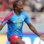 Merveille Kanjinga closes her eyes, spreads her arms and screams as she runs to celebrate a goal for DR Congo at the Women's Africa Cup of Nations in Morocco