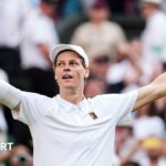 Jannik Sinner crouches to the ground after securing his first Wimbledon title