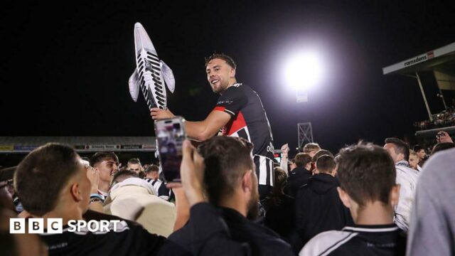 Reece Staunton is carried by fans holding an inflatable fish