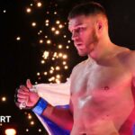 Vadim Nemkov enters the cage wrapped in a Russian flag