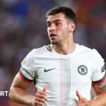 Marc Guiu looks on in a Chelsea shirt