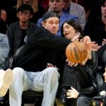 Justin Herbert z Chargers chráni Madison Beer pred basketbalom na videohre Lakers