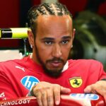 Lewis Hamilton nastupuje do červeného Ferrari F1