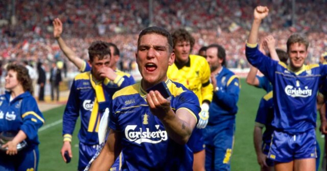 Vinnie Jones na ihrisku Wembley, zatiaľ čo jeho spoluhráči z Wimbledonu pochodujú za ním