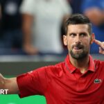 Novak Djokovic points to his ear as the crowd applauds him taking the second set to level the match