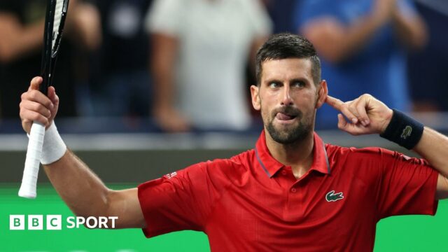 Novak Djokovic points to his ear as the crowd applauds him taking the second set to level the match