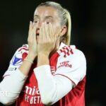 Arsenal striker Alessia Russo holds her hands to her face and looks dejected