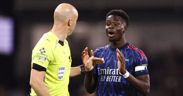 Rozhodca Anthony Taylor a Bukayo Saka počas zápasu Premier League medzi Fulhamom a Arsenalom v Craven Cottage. 