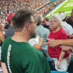 Staršia fanúšička Louisville, videná chvíľu po tom, čo v piatok večer udrela päsťou fanúšika z Miami