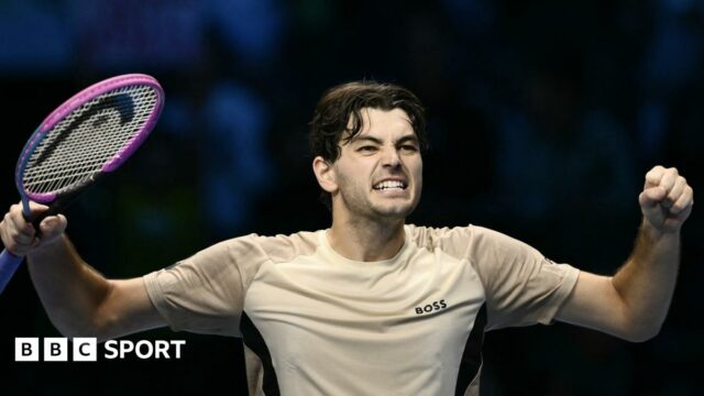 Taylor Fritz raises his arms in celebration after beating Lorenzo Musetti at the ATP Finals
