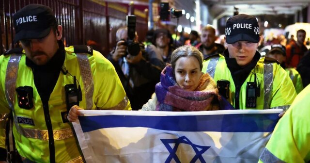 Policajti odprevadia ženu s izraelskou vlajkou preč od propalestínskych demonštrantov pred Villa Park