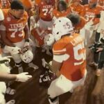 Skupinu texaských hráčov možno vidieť krúžiť okolo hnedého dresu Texas A&M