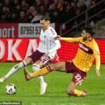 Obranca Motherwell Johnny Koutrombis vyzýva Alexandra Kyziridisa z Hearts vo Fir Parku