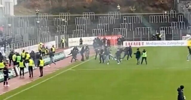 Futbaloví chuligáni spália súperovu vlajku a stretnú sa s políciou Fanúšikovia sa ponáhľali na ihrisko, keď polícia odpovedala