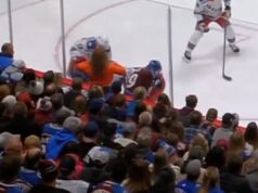 Hokejová fanúšička bliká na hráčov z prvého radu na zápase Rangers Fanynka pozdĺž skla na zápase Avalanche-Rangers si vo štvrtok vyhrnula tričko