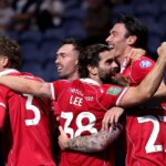 Útočník Wrexhamu Kieffer Moore oslavuje so svojimi spoluhráčmi po strelenom góle