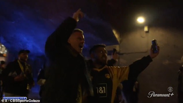 Jamie Carragher nesie svetlicu a pije plechovku piva s fanúšikmi Jamie Carragher sa v stredu pripojil k fanúšikom Borussie Dortmund na ich predzápasovom pochode