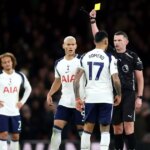 Rozhodca Michael Oliver ukazuje žltú kartu Cristianovi Romerovi z Tottenhamu Hotspur počas zápasu Premier League medzi Arsenalom a Tottenhamom Hotspur na Emirates Stadium 23. novembra 2025 v Londýne v Anglicku.