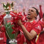 Trent Alexander-Arnold lifts the Premier League trophy on his final Liverpool appearance at Anfield.