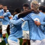Manchester City players celebrate scoring against Liverpool together