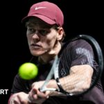 Jannik Sinner hits a backhand