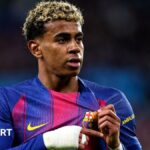 Lamine Yamal holds the Barcelona badge on his shirt