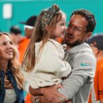 Tréner Dolphins Mike McDaniel (vpravo) drží dcéru Aylu June v strede vedľa, zatiaľ čo jeho manželka Katie Hemstalk vľavo stojí neďaleko. McDaniel je triezvy od januára 2016
