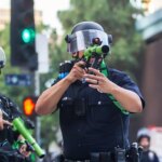 Policajti z Los Angeles (LAPD) mieria gumovými projektilmi na dav počas pochodu v centre mesta proti americkému prezidentovi Donaldovi Trumpovi 14. júna 2025 v Los Angeles v Kalifornii.