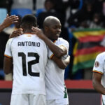 Futbalistovi Zimbabwe Knowledge Musonovi v bielom tričku gratulujú jeho spoluhráči po skórovaní na turnaji Africký pohár národov 2025
