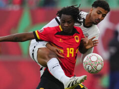 Egypt odpočíva Salah ako Angola na pokraji východu z Afconu Futbalista Fredy v červenom tričku so žltými detailmi a jeho menom a číslom 16 na chrbte v žltej farbe strieľa loptu z priameho kopu pre Angolu proti Egyptu na Afcon 2025. Piati hráči Egypta v bielom drese s čiernym lemovaním a čiernymi číslami vpredu vyskočili do vzduchu a pokúsili sa zachytiť loptu, zatiaľ čo Fredyho spoluhráč na chrbte, Maestro, sa pozerá na strelu.