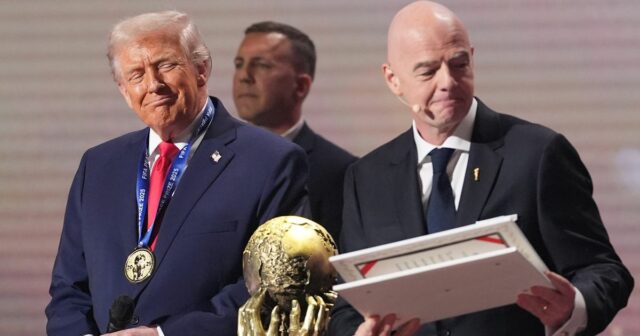 Prezident Donald Trump stojí na pódiu po prevzatí ceny FIFA za mier