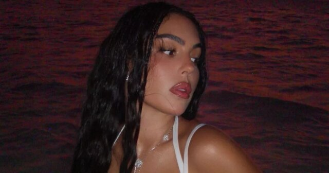 Georgina Rodriguez robí drzý vtip, zatiaľ čo dvíha veko na Georgina Rodriguez a Cristiano Ronaldo, pričom jeden jedinec dal druhému bozk na líce. Zdá sa, že scéna je zasadená do slabo osvetleného prostredia, pričom ich črty zvýrazňuje jemné osvetlenie.