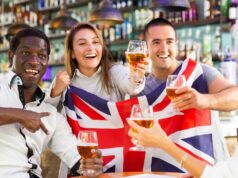 Krčmy idú do predĺženia, ak Anglicko alebo Škótsko dosiahnu majstrovstvá sveta v neskorších fázach Muži a ženy pijú pivo a oslavujú úspech športového tímu, mávajú vlajkou Veľkej Británie, muž ukazuje víťazný znak v bare